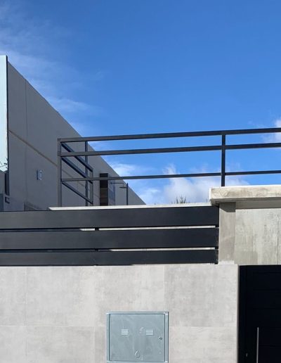 Barandilla de lamas anchas con separación milimétrica y pasamanos tubular