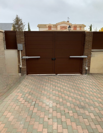 Cancela batiente de doble hoja motorizada con lamas horizontales ciegas