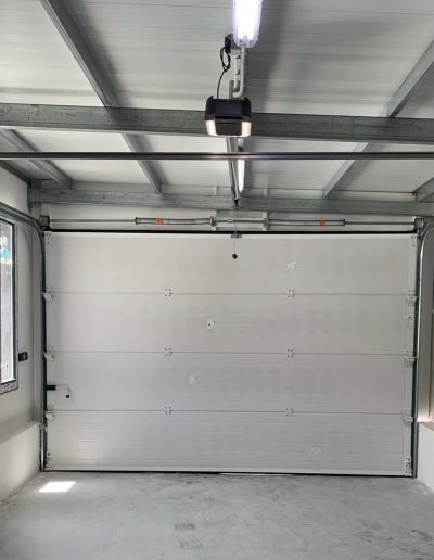 Vista interior de puerta seccional de garaje y guías de deslizamiento