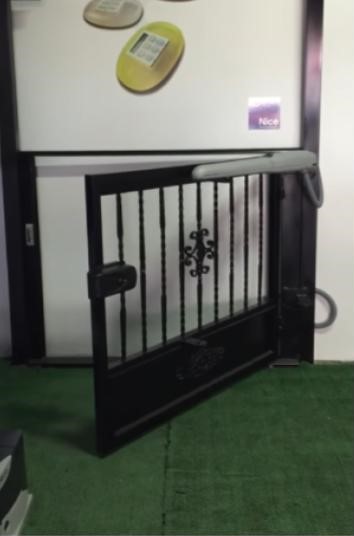 Maniobra de Apertura Silenciosa: Tecnología NICE Wingokit Detalle de la maniobra de una puerta abatible equipada con el motor NICE Wingokit en funcionamiento.