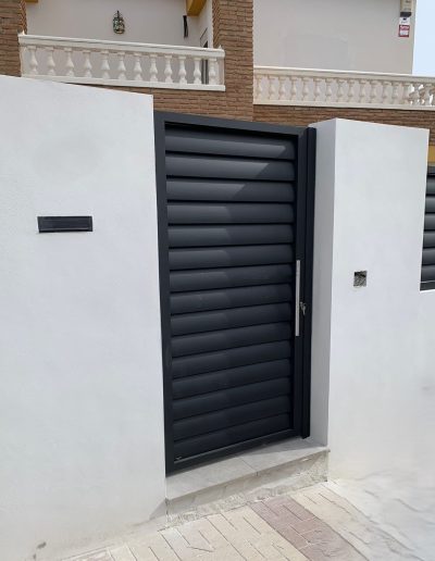 Puerta exterior con sistema de lamas para ventilación y flujo de aire