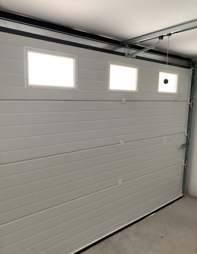 Puerta de garaje seccional con ventanillas rectangulares superiores